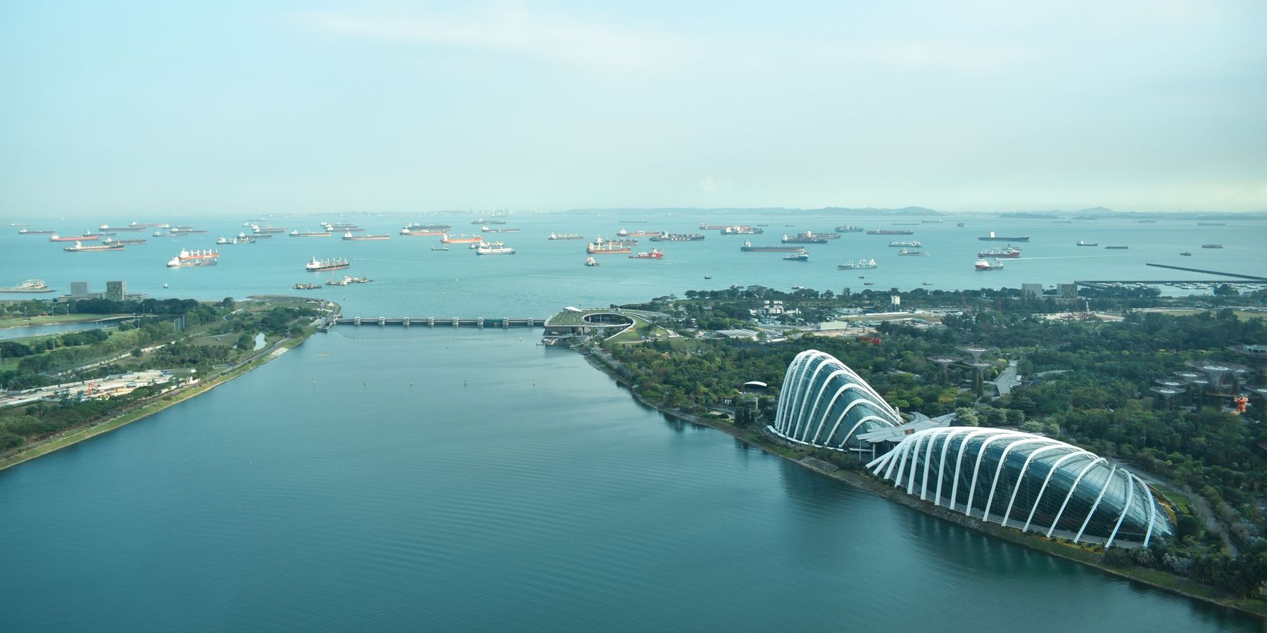 Gardens by the Bay and Marina Barrage with ships anchored offshore