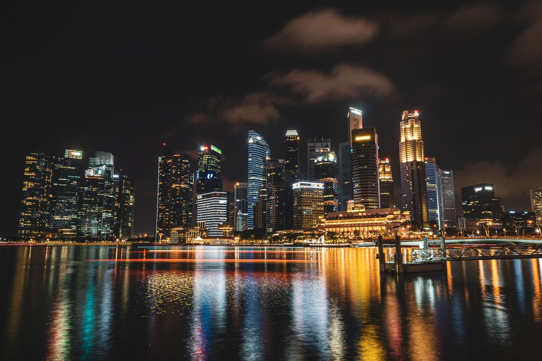 The Marina Bay skyline lit up at night, its colours reflected in the water