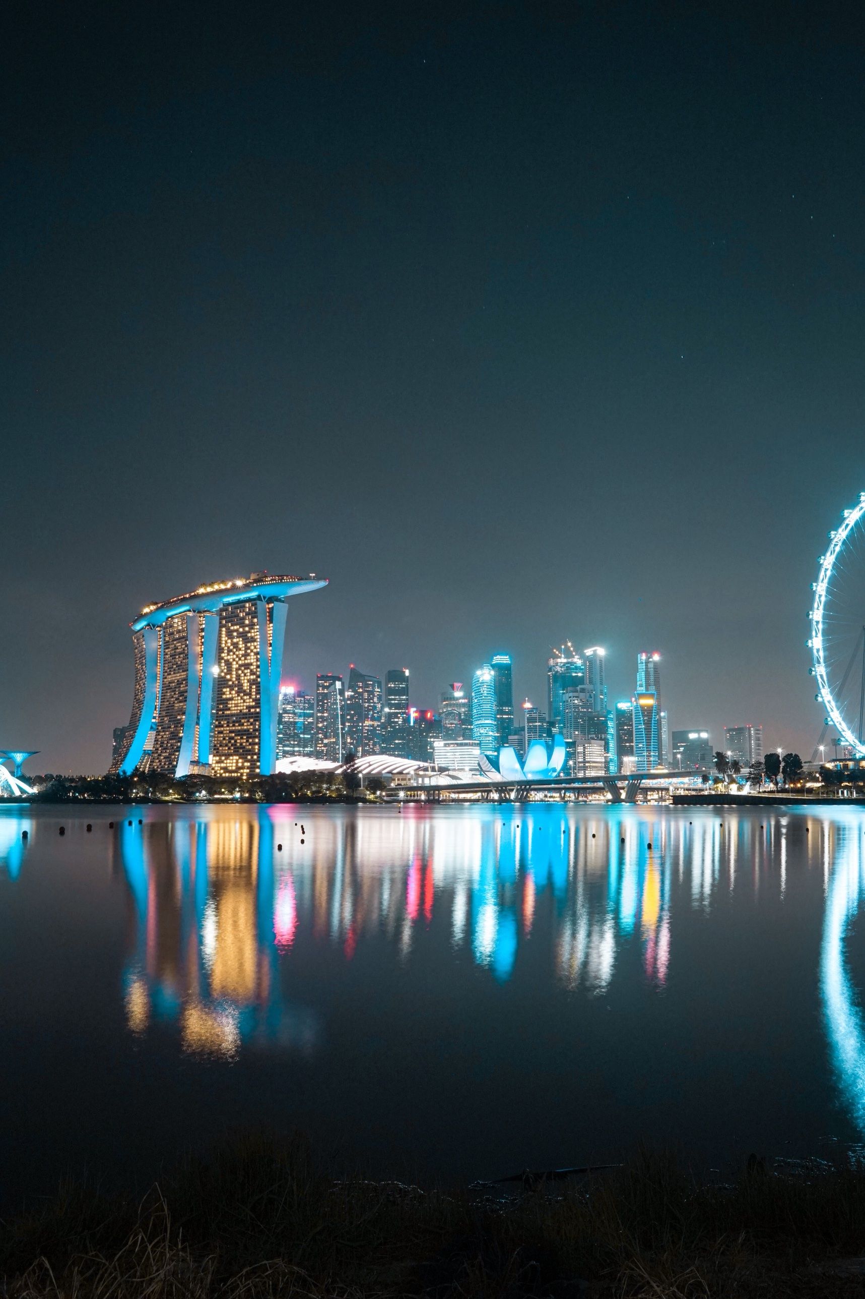 Marina Bay Sands, the skyline and the Singapore Flyer reflected in the bay at night