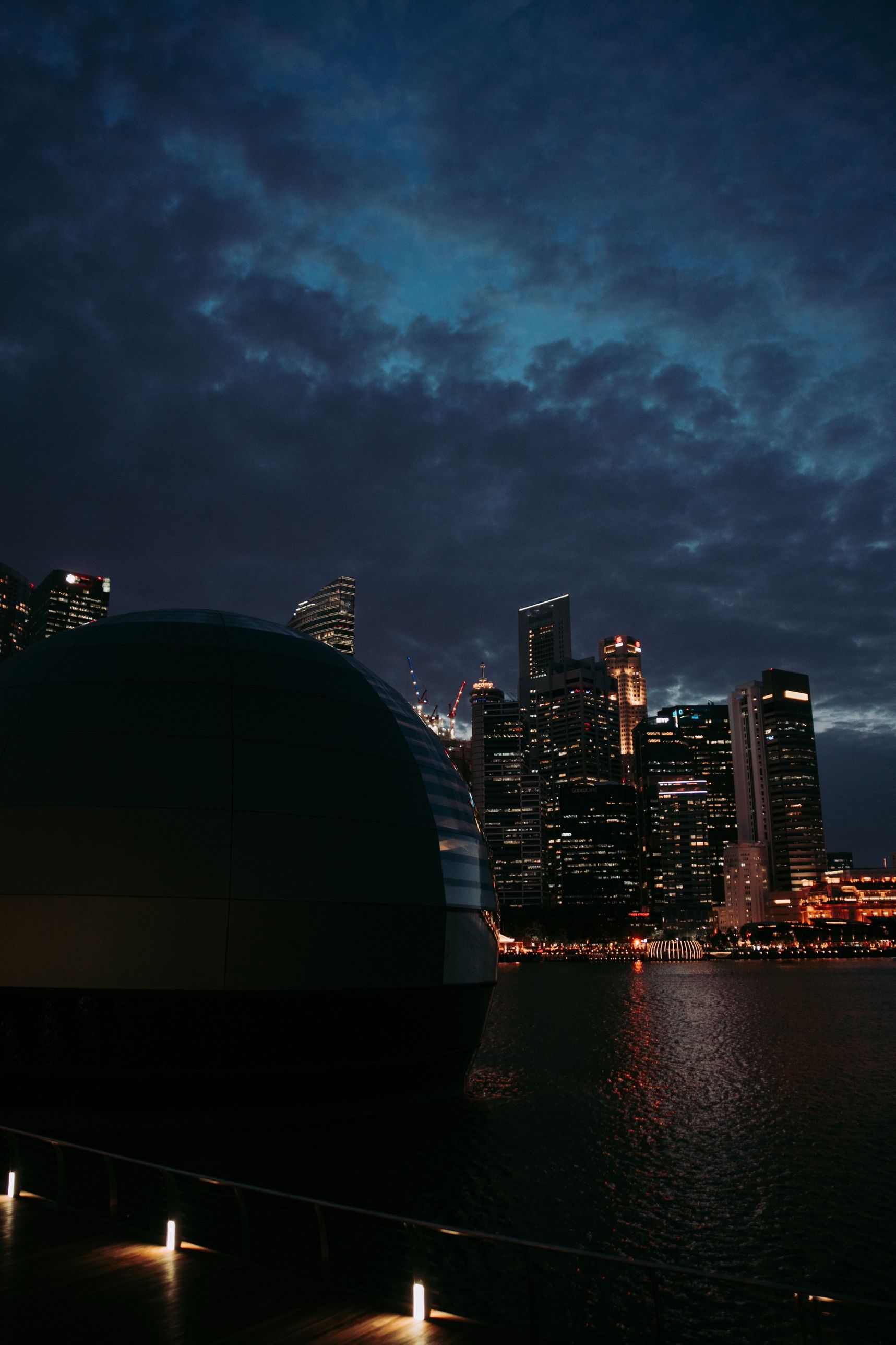 The waterfront at dusk with the city towers under heavy cloud